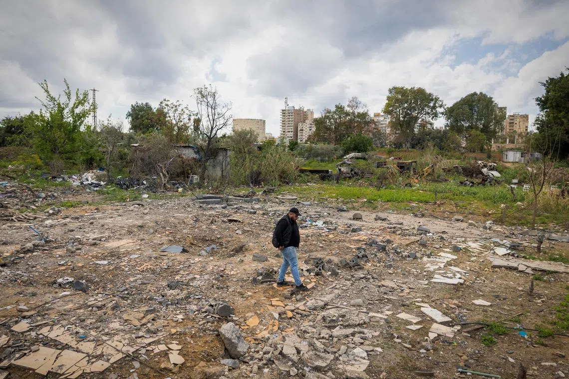 Hussein Saleh, 34, walks on the rubble of his house destroyed in an Israeli airstrike, which killed members of his family, amid escalating hostilities between Israel and Hezbollah, as the U.S.-Israeli conflict with Iran continues, in Tyre, Lebanon, April 7, 2026. REUTERS/Adnan Abidi