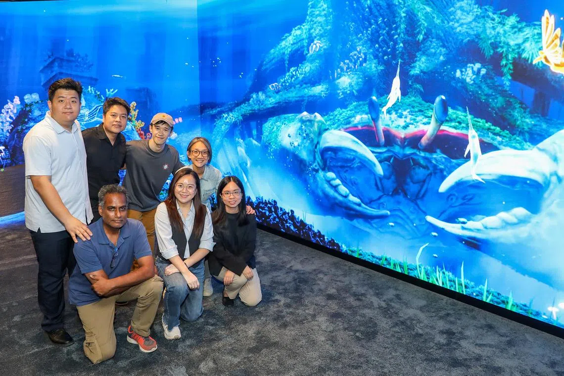 kgglass - ST20250723_202554900456. Luther Lau. Group pix of Standing (top from left): Ash Mo Naiming, Systems Integration Manager Brian Gothong Tan, Creative Director Joshua Tan, Multimedia Director Priscilla Chua, Principal Curator at National Museum of Singapore (Bottom row:) Subash Chakrapani, Project Manager, Melissa Chan Art and Design Director, Jan Yap, Assistant Curator,  National Museum of Singapore with one of their showcases for content in the newly revamped Glass rotunda. Taken at the National Museum of Singapore.