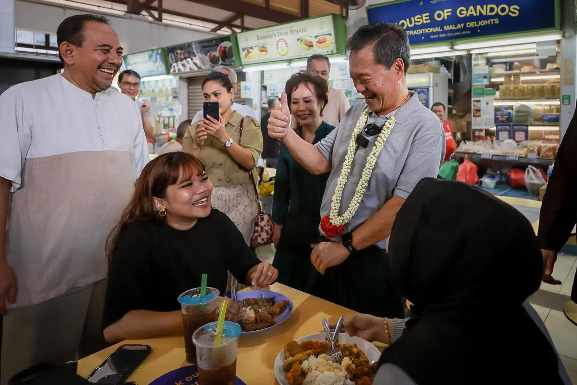 Presidential candidate Tan Kin Lian, accompanied by his wife Tay Siew Hong (on his right), greeting patrons at Geylang Serai Market and Food Centre on Aug 25.