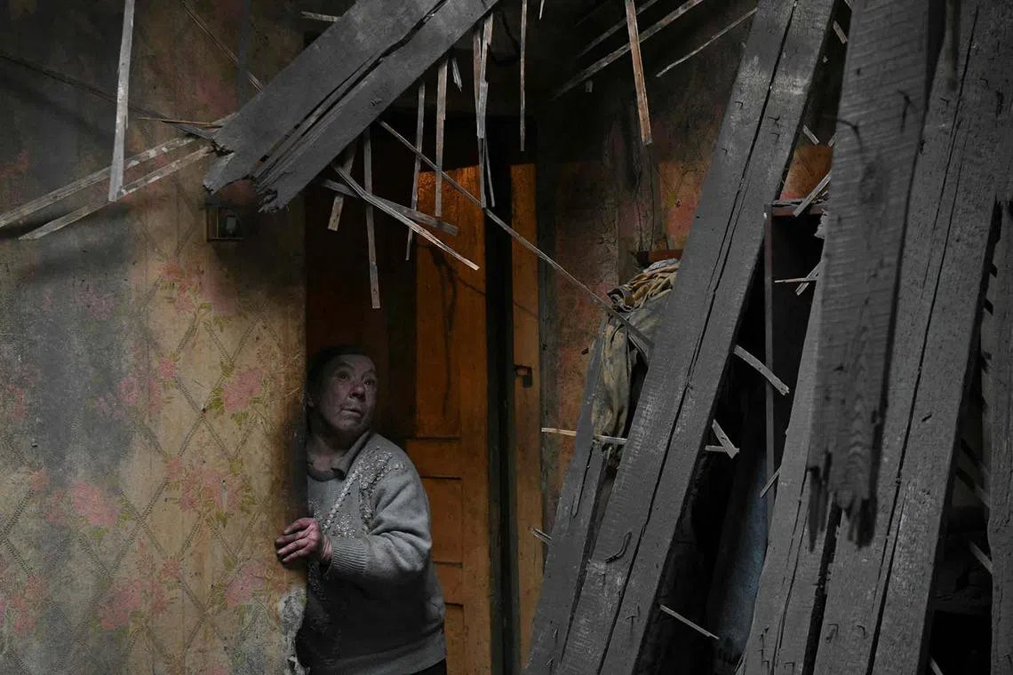 TOPSHOT - A local resident reacts standing inside her flat damaged by recent shelling in Donetsk, Russian-controlled Ukraine, on December 12, 2023, amid the Russia-Ukraine conflict. (Photo by STRINGER / AFP)
