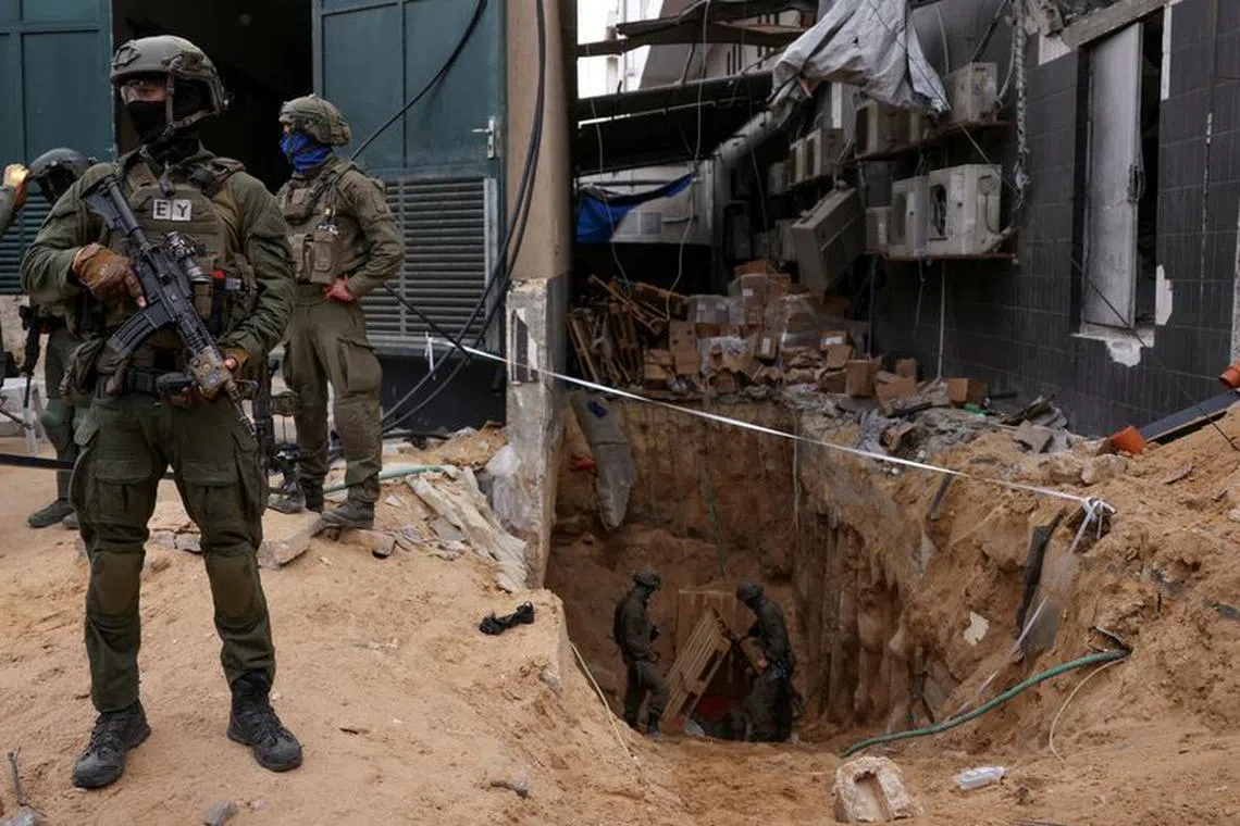 Israeli soldiers stand near the opening to a tunnel at Al Shifa Hospital compound in Gaza City, amid the ongoing ground operation of the Israeli army against Palestinian Islamist group Hamas, in the Gaza Strip, November 22, 2023. REUTERS/Ronen Zvulun
