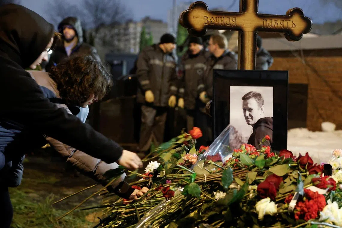 FILE PHOTO: People lay flowers at the grave of Russian opposition politician Alexei Navalny following his funeral at the Borisovskoye cemetery in Moscow, Russia, March 1, 2024. REUTERS/Stringer/File Photo