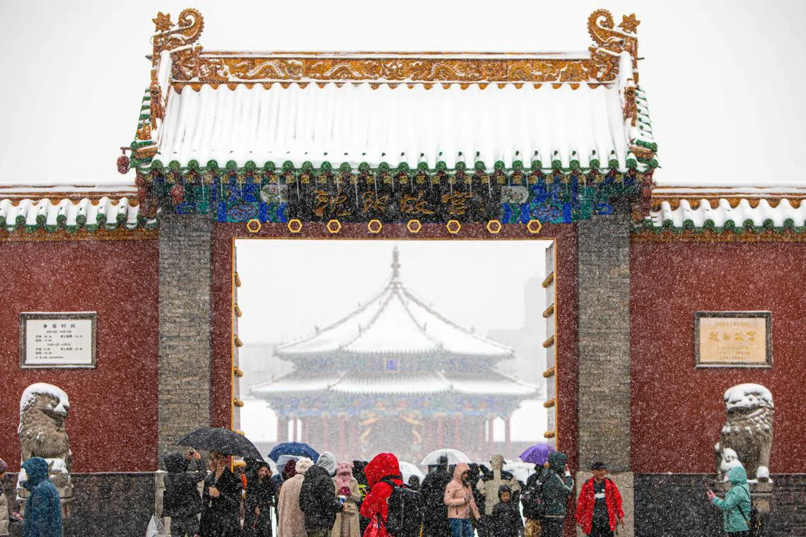 This photo taken on November 6, 2023 shows people visiting the Shenyang Imperial Palace as it snows in Shenyang, in China's northeastern Liaoning province. (Photo by AFP) / China OUT