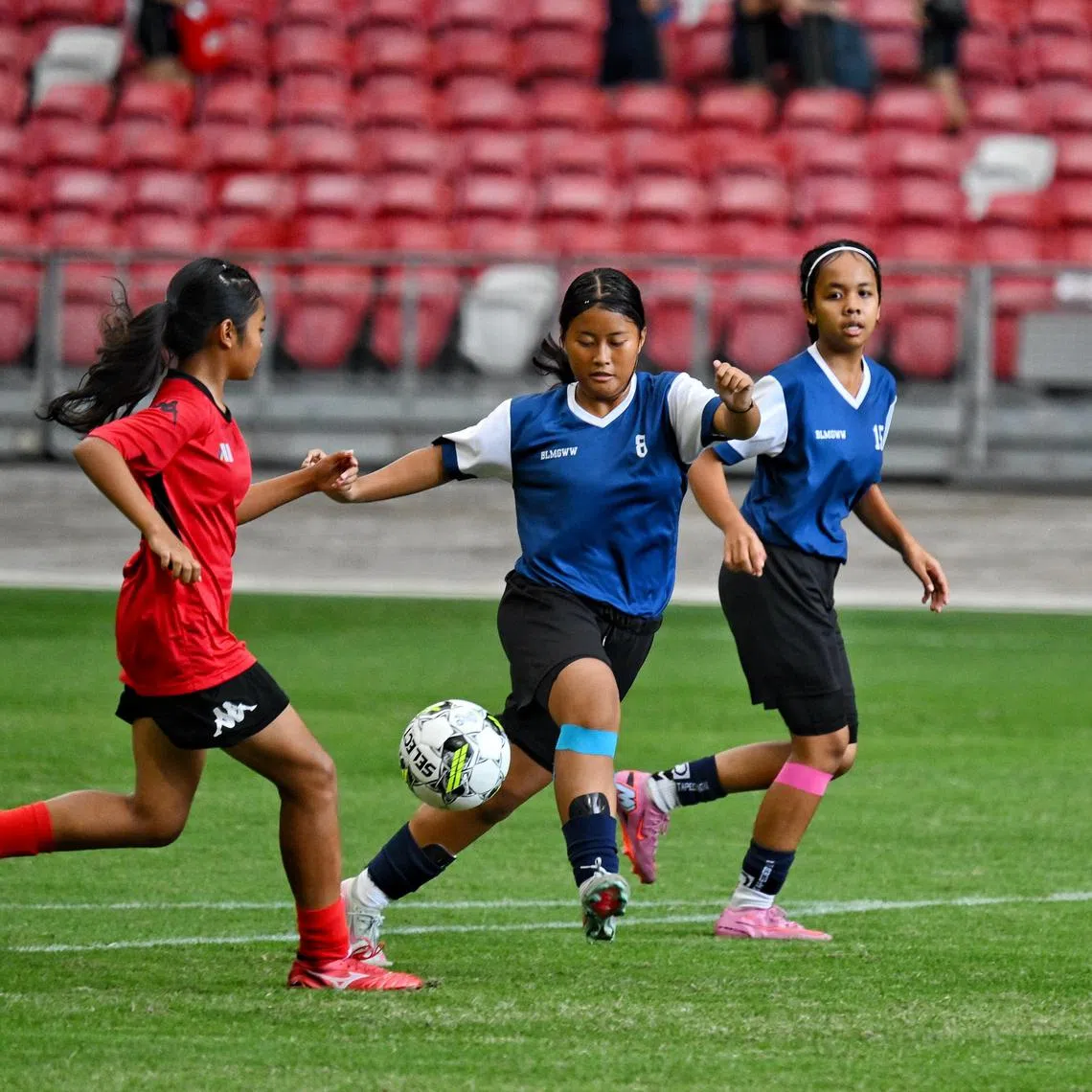 Dania Adlina (centre, in blue) from CBP W3, combined team comprising players from Boon Lay Secondary, Methodist Girls' School and Westwood Secondary, at the C division football finals against Meridian Secondary School on Aug 13, 2025. 

ST PHOTO: AZMI ATHNI