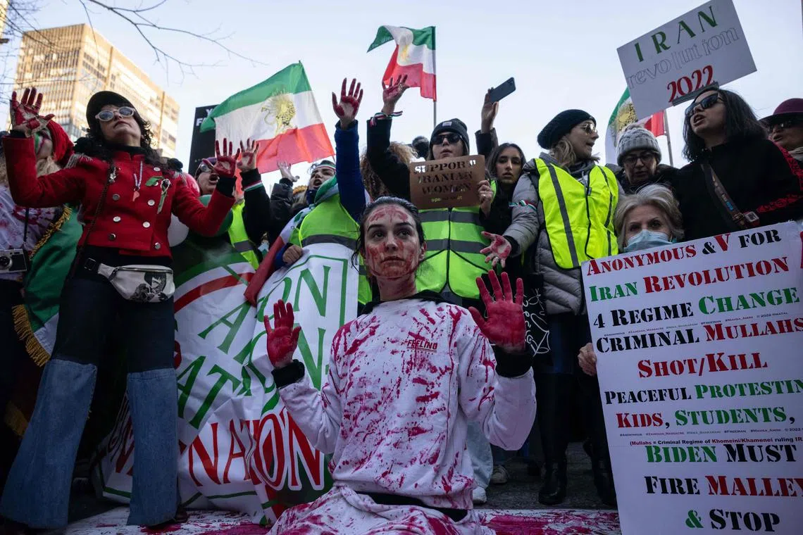 (FILES) Naz Gharai, from Tehran, is covered in red paint as protesters call on the United Nations to take action against the treatment of women in Iran, following the death of Mahsa Amini while in the custody of the morality police, during a demonstration near UN headquarters in New York City on November 19, 2022. Persecution of bereaved relatives. Impunity for perpetrators. Rampant executions and infighting among the opposition. A bleak picture confronts opponents of Iran's clerical authorities two years after a protest movement erupted that they hoped would be a turning point in the four-and-a-half-decade history of the Islamic republic. (Photo by Yuki IWAMURA / AFP)
