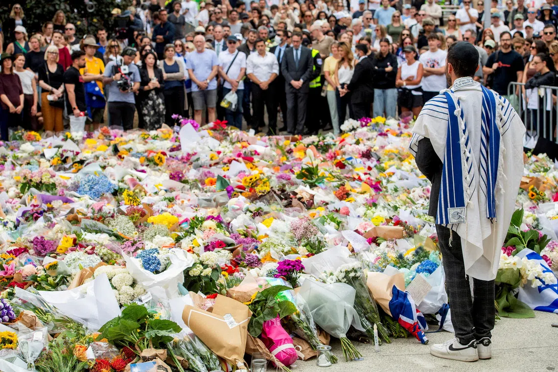 A member of the Jewish community stands at a floral memorial in honour of the victims of the mass shooting targeting a Hanukkah celebration at Bondi Beach, in Sydney, Australia, on Dec 16, 2025.