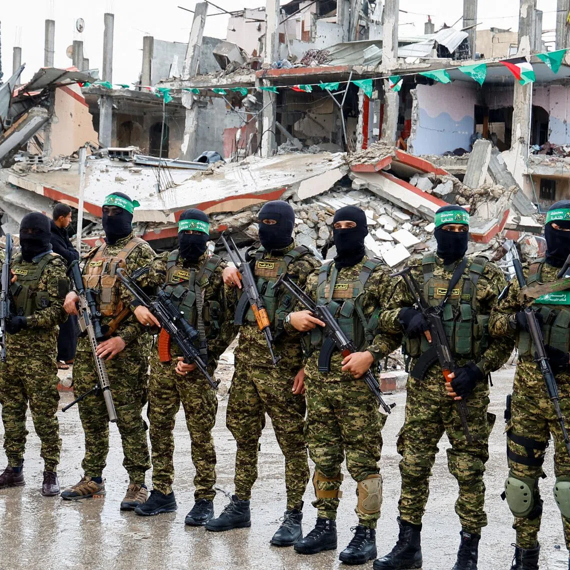 FILE PHOTO: Palestinian Hamas militants stand guard on the day of the handover of hostages held in Gaza since the deadly October 7 2023 attack, as part of a ceasefire and a hostages-prisoners swap deal between Hamas and Israel, in Rafah in the southern Gaza Strip, February 22, 2025. REUTERS/Hatem Khaled/File Photo