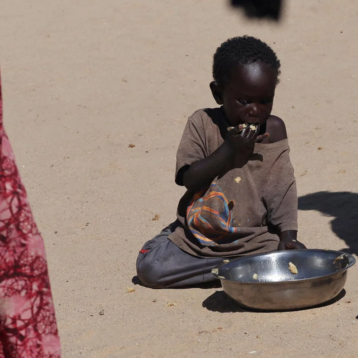 FILE PHOTO: A Sudanese orphaned child refugee from al-Fashir eats a free meal provided by the ?Group Kitchen Project? inside the Tine transit camp in eastern Chad, amid the conflict between the paramilitary Rapid Support Forces (RSF) and the Sudanese army, November 22, 2025. REUTERS/Amr Abdallah Dalsh/File Photo