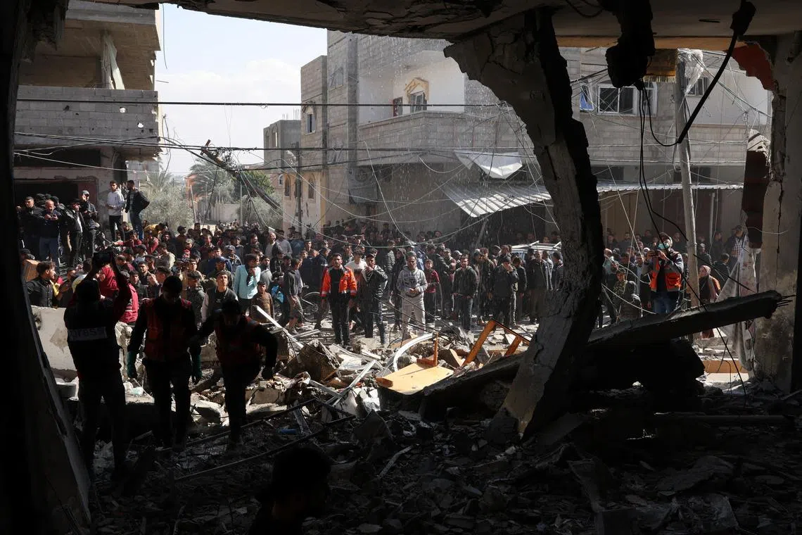 Palestinians gather at the site of an Israeli strike on a house, amid the ongoing conflict between Israel and Hamas, in Rafah, in the southern Gaza Strip February 24, 2024. REUTERS/Ibraheem Abu Mustafa/File Photo