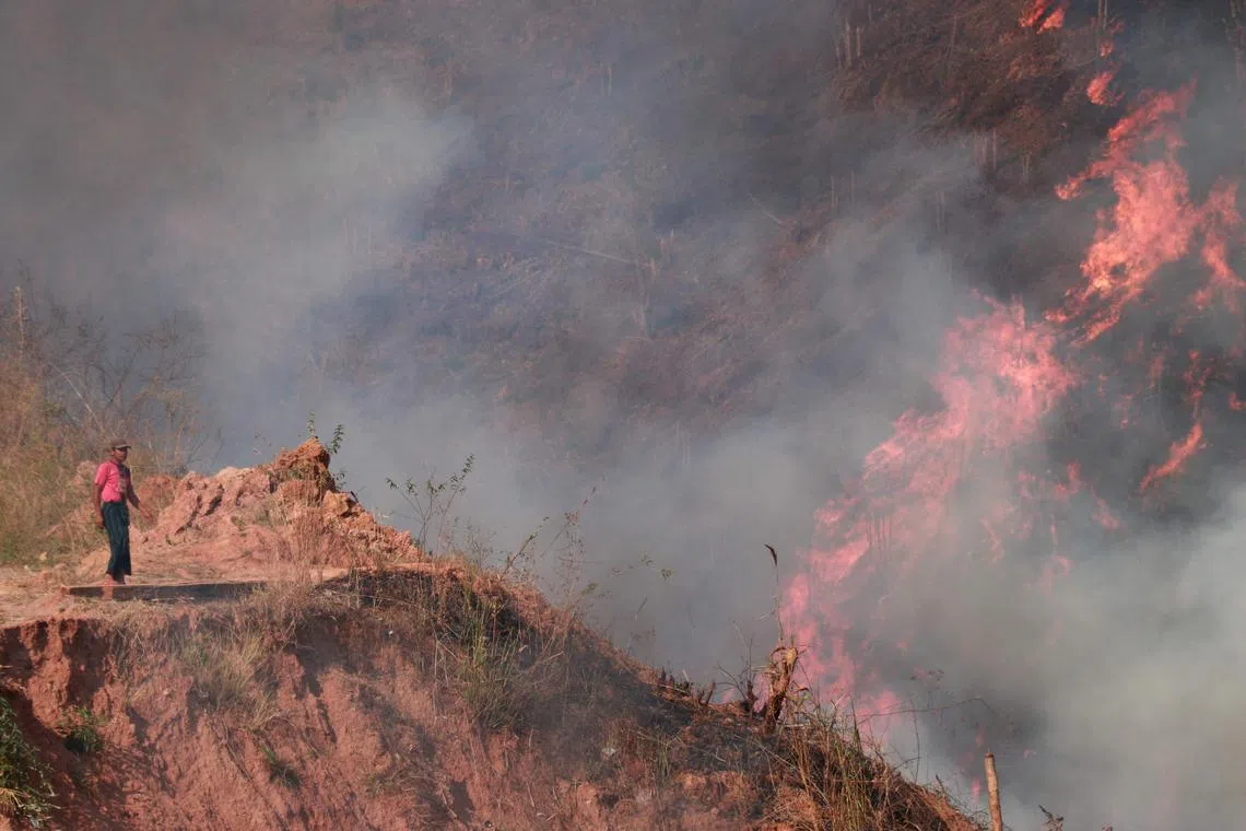 A man standing near burning paddy stubble during a slash-and-burn farming festival at Hseebu area in Pekon township, Myanmar. 