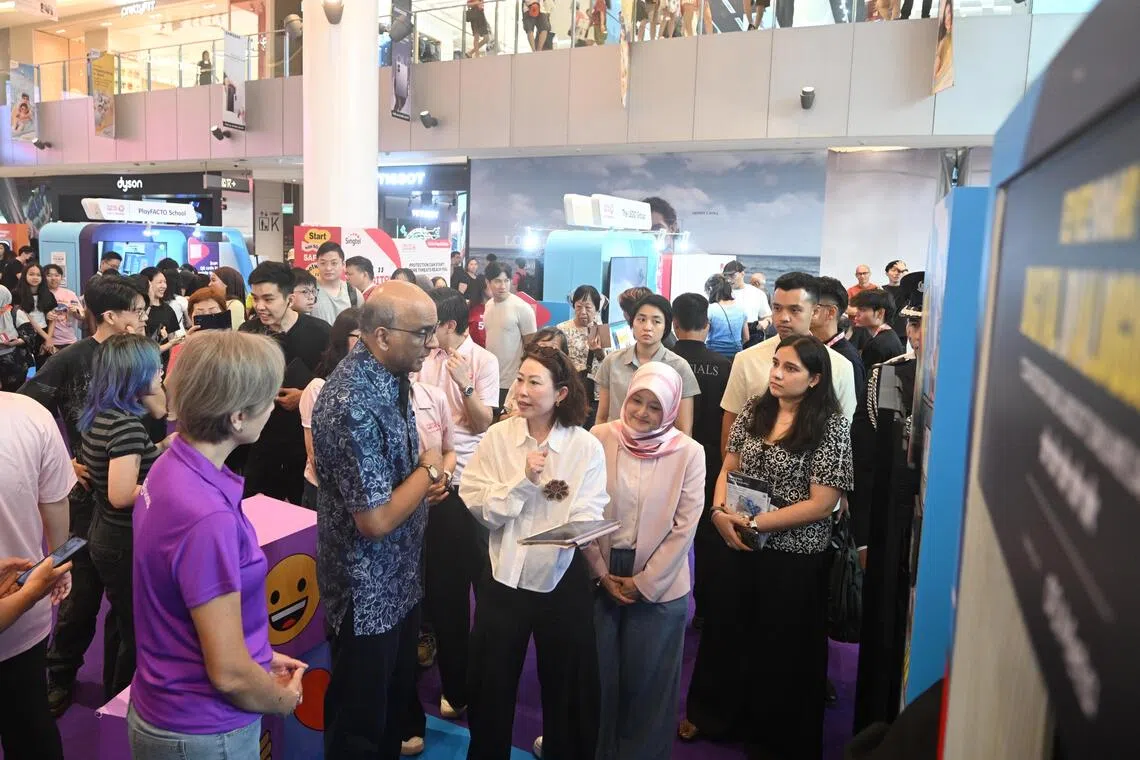 President Tharman Shanmugaratnam (centre) with Minister for Digital Development and Information Josephine Teo (left) and Minister of State for Digital Development and Information Rahayu Mahzam (fourth from left) touring the exhibitions at the Digital for Life Festival, on Oct 24.