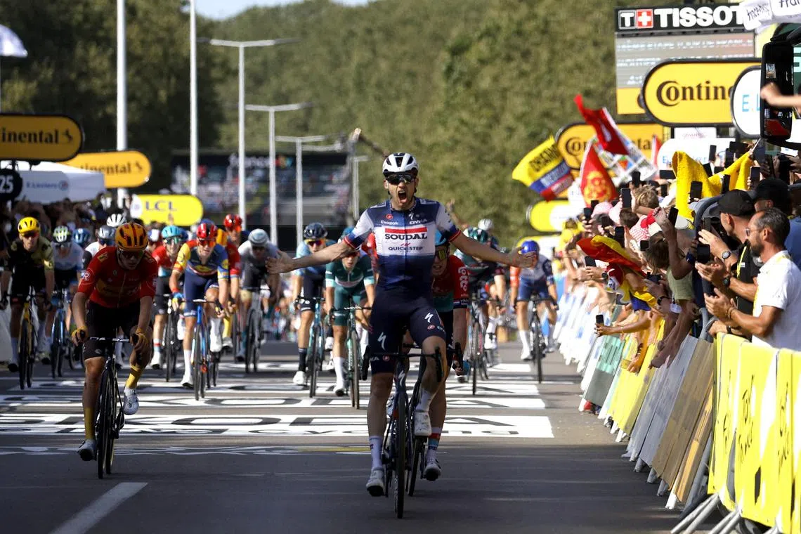 Soudal–Quick-Step's Kasper Asgreen celebrates as he crosses the finish line to win stage 18.