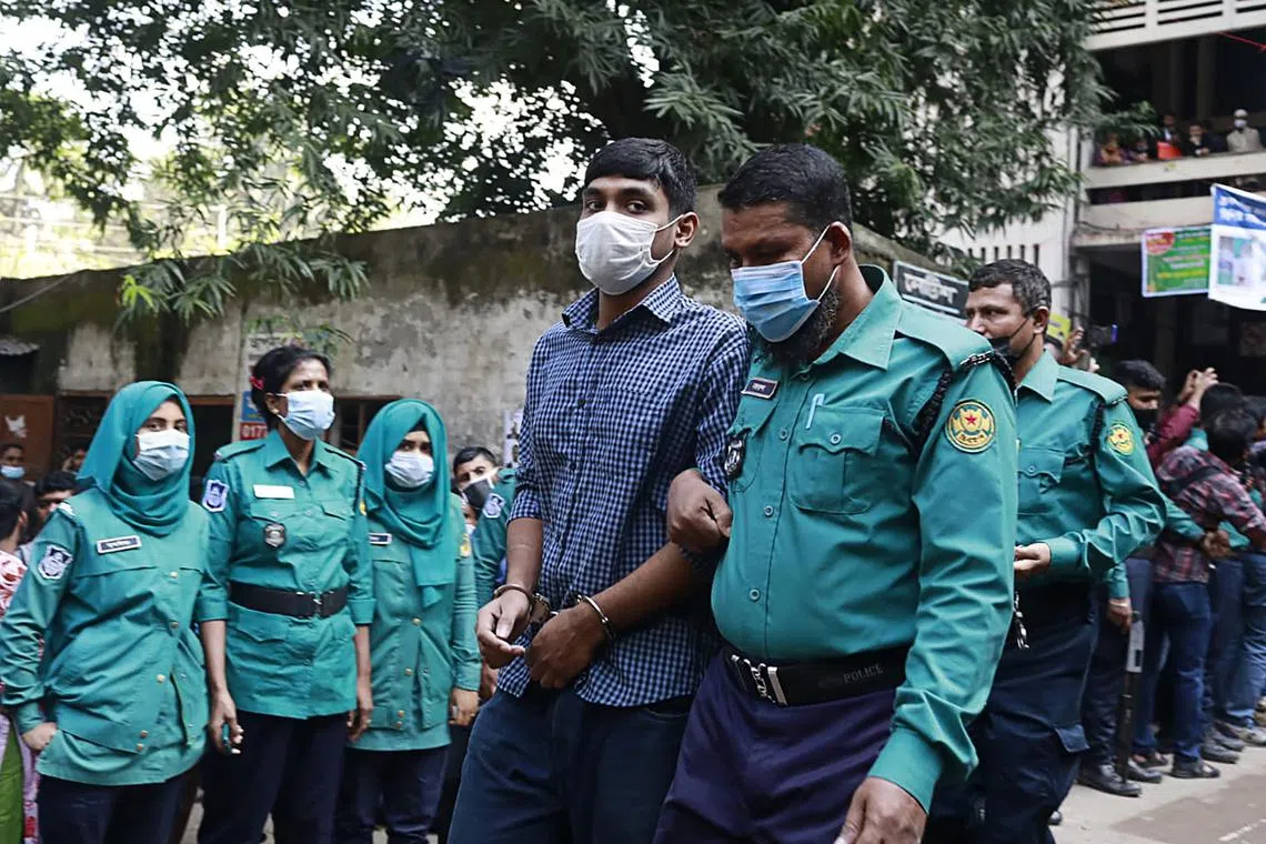 Police escort one of 20 university students sentenced to death for the brutal 2019 murder of Mr Abrar Fahad, who criticised the government on social media in this Dec 8, 2021 file photo. On Sunday, two extremists on death row over another social media murder case escaped from a court in Dhaka.