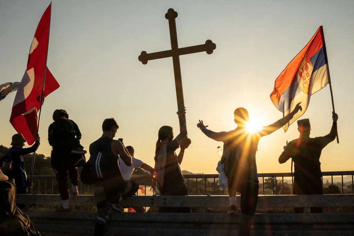 Students from Gornji Milanovac wave flags during their walk to Belgrade near the village of Bogovadja, Serbia, October 19, 2026. REUTERS/Marko Djurica