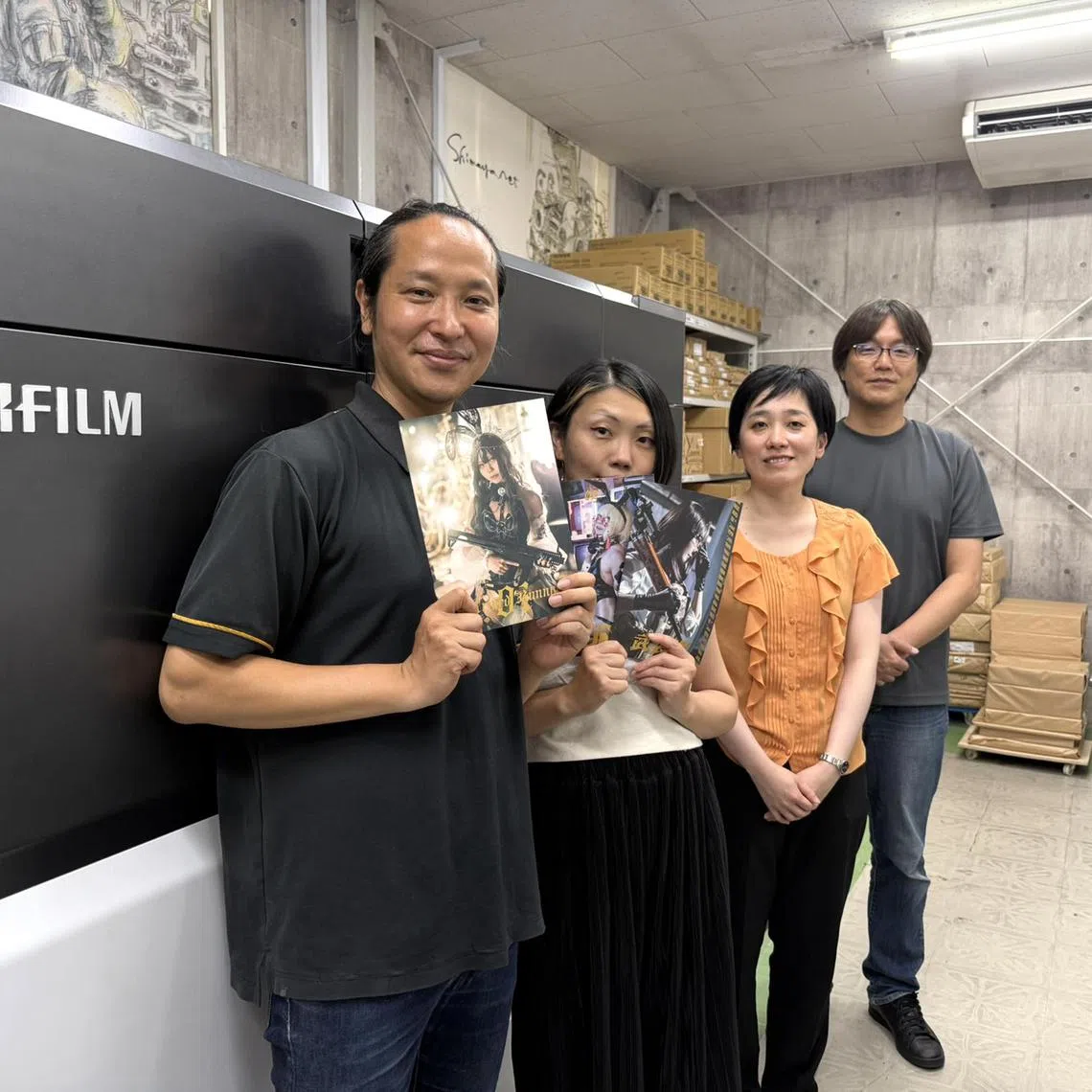 wsletter01 - (L-R) Mr Shinji Kashida and his wife Misato hold up doujinshi photo collections of the latter cosplaying, with Ms Makiko Bujo, 39, of the graphic communication division at Fujifilm Business Innovation Japan, and Mr Masaki Kohayakawa, 53, chief executive officer of Shimaya Printing Corporation, at Shimaya's factory in Tokyo.

ST PHOTO: WALTER SIM