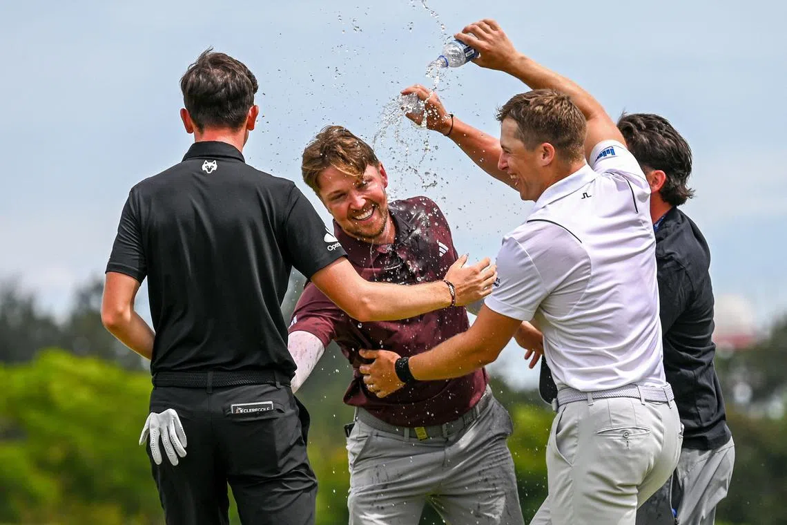 England's Richard Mansell being doused in water by his rivals after winning the Porsche Singapore Classic at Laguna National Golf Resort Club on March 23.