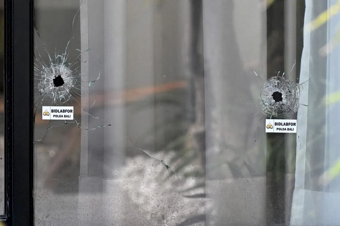Bullet holes are seen in the glass door of a villa, where one Australian was shot dead and another wounded, in Munggu village, Badung regency on the Indonesian resort island of Bali on June 15, 2025.