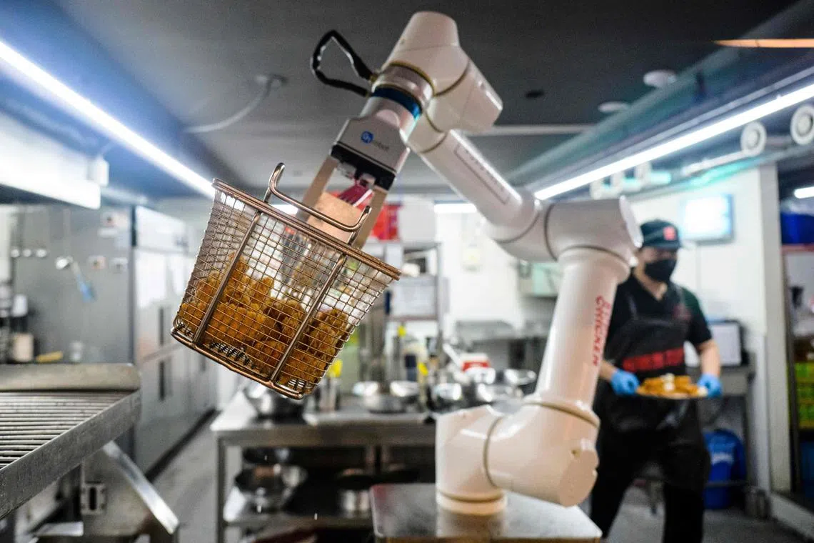 A robot frying chicken at a Robot Chicken restaurant in Seoul.