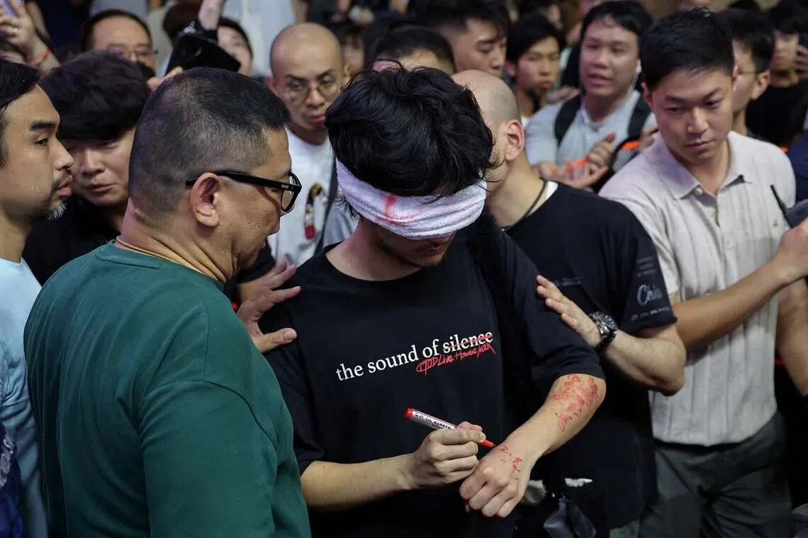 Plain-clothes police detaining a man holding a marker pen, near Victoria Park, the historic site of Tiananmen Square vigils, in Hong Kong, China, June 4.