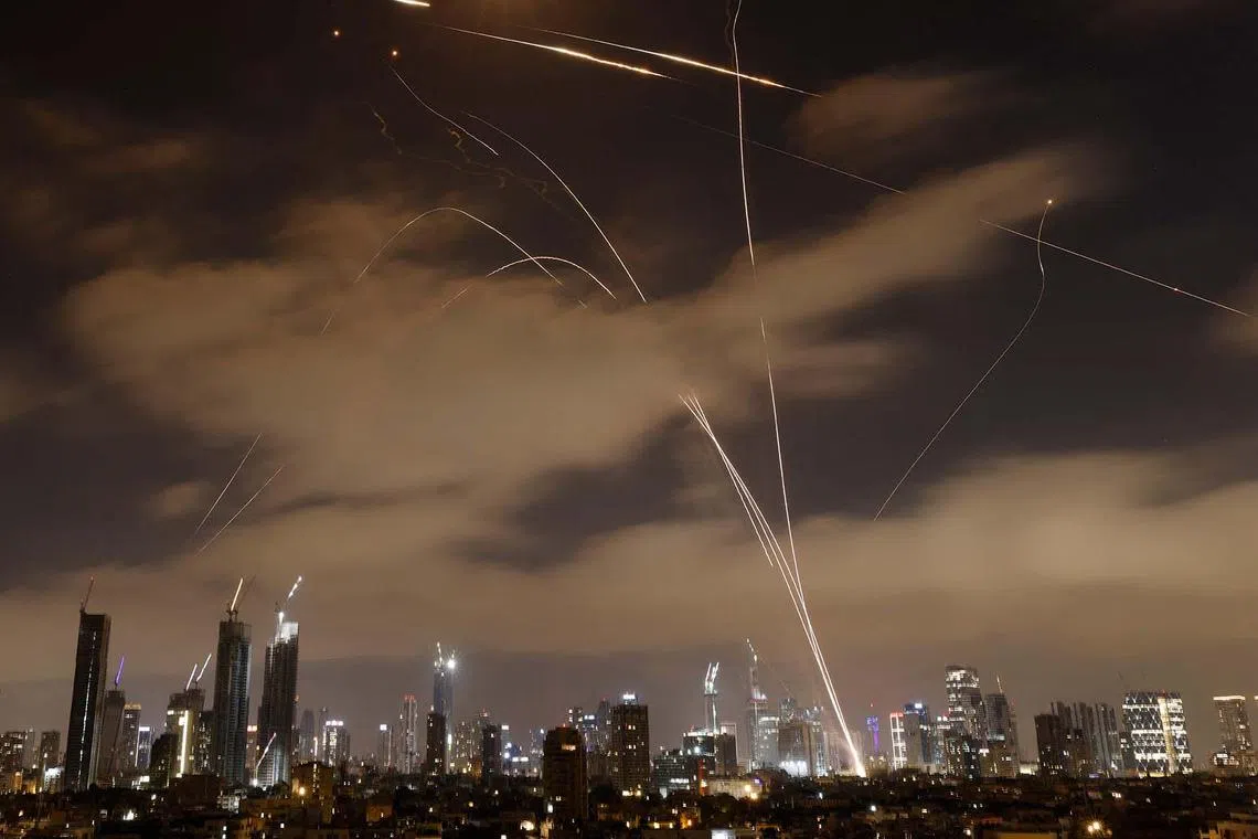 TOPSHOT - Israeli air defence systems intercept Iranian missiles over the Israeli city of Tel Aviv early on June 15, 2025. Air raid sirens and booms rang out in Jerusalem and Tel Aviv early on June 15, AFP journalists said, as Israel and Iran exchanged fire for a third day. (Photo by Jalaa MAREY / AFP)