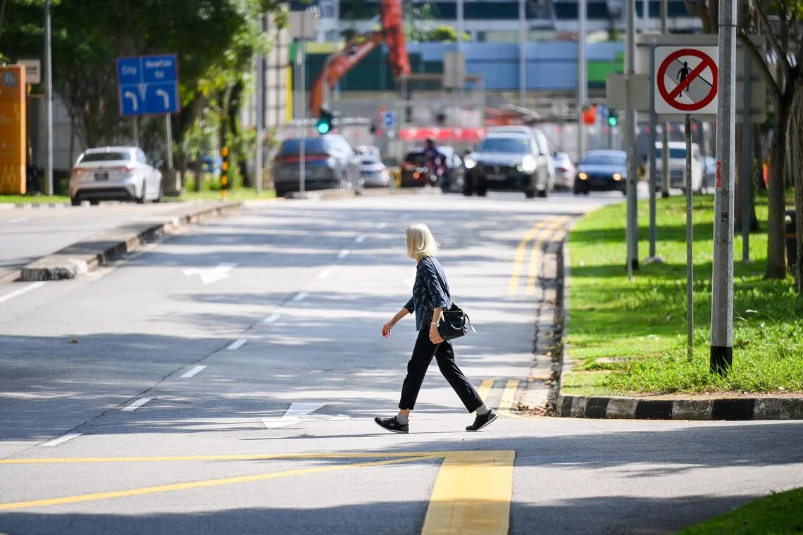 An elderly woman jaywalking along Irrawaddy Road in May. The number of elderly folk who died in accidents more than doubled from 11 in 2024 to 27 in 2025.