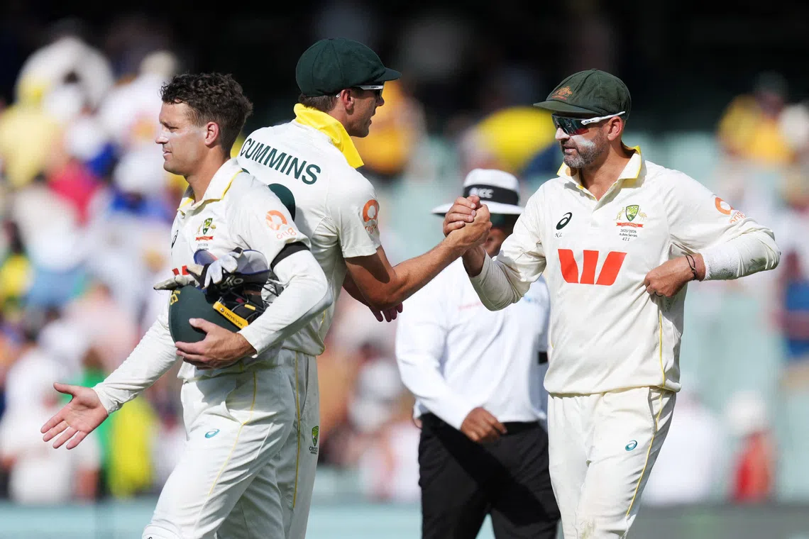FILE PHOTO: Cricket - The Ashes - Australia v England - Third Test - Adelaide Oval, Adelaide, Australia - December 20, 2025 Australia's Pat Cummins shakes hands with Nathan Lyon as they walk off the field at stumps on day 4 REUTERS/Asanka Brendon Ratnayake/File Photo