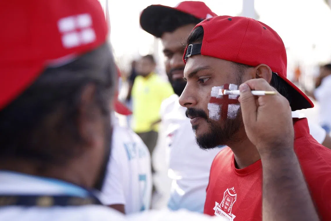 A England fan in Doha has his face painted ahead of the World Cup.