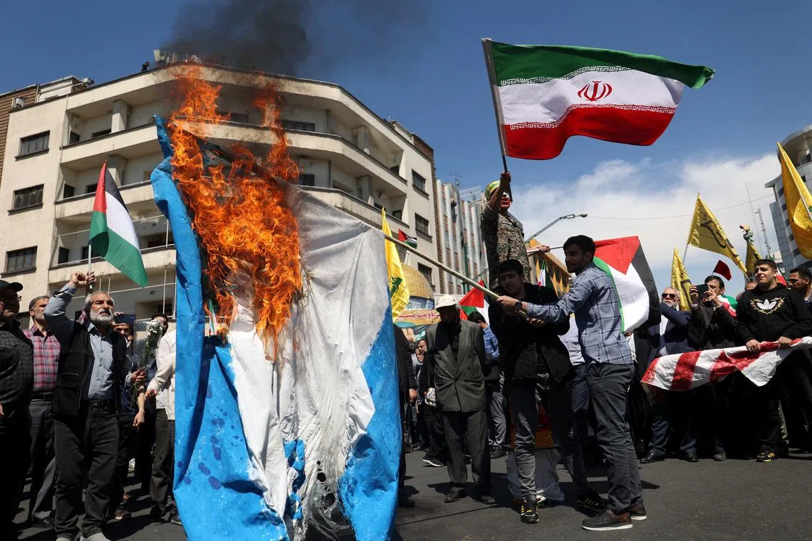 FILE PHOTO: Iranians burn an Israeli flag during a rally marking Quds Day and the funeral of members of the Islamic Revolutionary Guard Corps who were killed in a suspected Israeli airstrike on the Iranian embassy complex in the Syrian capital Damascus, in Tehran, Iran, April 5, 2024. Majid Asgaripour/WANA (West Asia News Agency) via REUTERS/File Photo