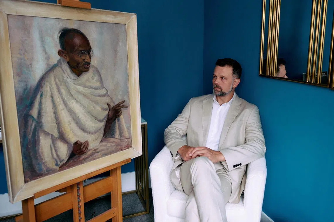 Mr Caspar Leighton poses with an oil painting by his great-aunt, the artist Clare Leighton, of Indian independence leader Mahatma Gandhi.