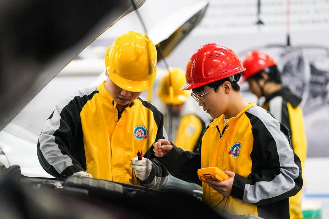 Students learning to repair a new energy vehicle at a training centreof Anhui Wantong Technician College on Dec 10. 