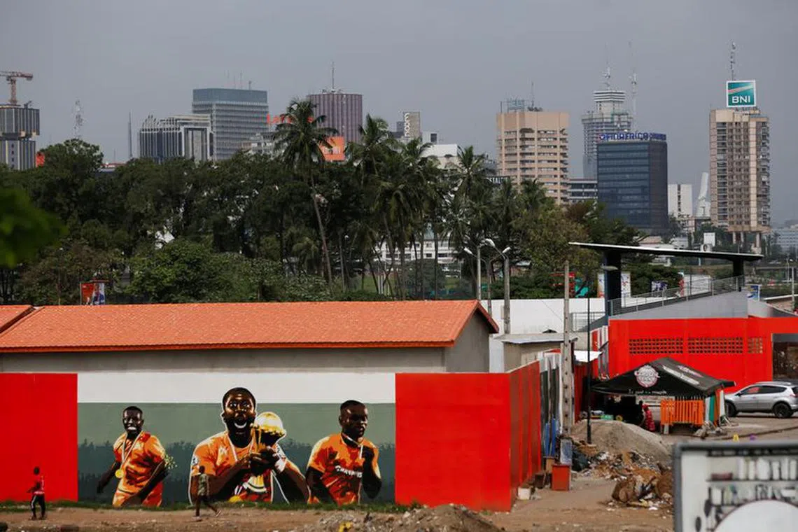 People pass in front of graffiti showing the Ivory Coast team winners of the 2015 Africa Cup of Nations, as Ivory Coast gears up to host the Africa Cup of Nations which begins on Saturday, in Abidjan, Ivory Coast January 7, 2024. REUTERS/Luc Gnago/File Photo