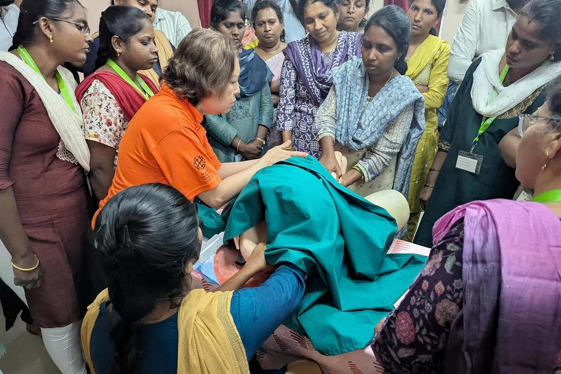 rmmother - A senior nurse from SingHealth (orange shirt) shows doctors and nurses from primary healthcare centres how to deliver a child in breach using a mannequin in a simulation exercise in Chennai. Several medical professionals from Singapore have volunteered to collaborate with the Tamil Nadu health department to improve maternal and child health and reduce mortalities with refresher programmes and protocol reviews.
ST PHOTO: ROHINI MOHAN