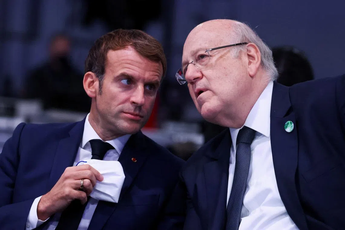 FILE PHOTO: Lebanese Prime Minister Najib Mikati speaks with French President Emmanuel Macron, as they attend the UN Climate Change Conference (COP26) in Glasgow, Scotland, Britain, November 1, 2021. REUTERS/Yves Herman/Pool/File Photo
