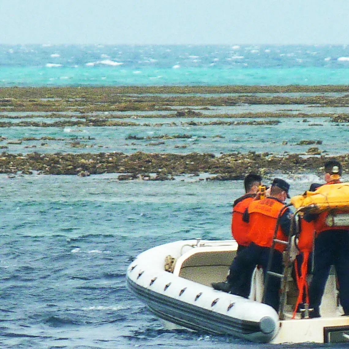 In this photo taken on December 25, 2022, Chinese coast personnel aboard an inflatable boat patrol Scarborough Shoal in the South China Sea. (Photo by AFP)