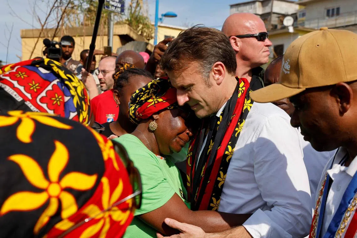 French president Emmanuel Macron embracing a woman as he speaks with local residents during his visit to Mayotte, on Dec 19.