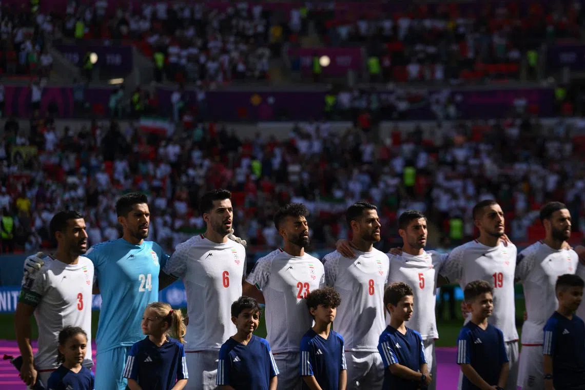 Iranian football players sing the national anthem ahead of the match against Wales on Nov 25, 2022.