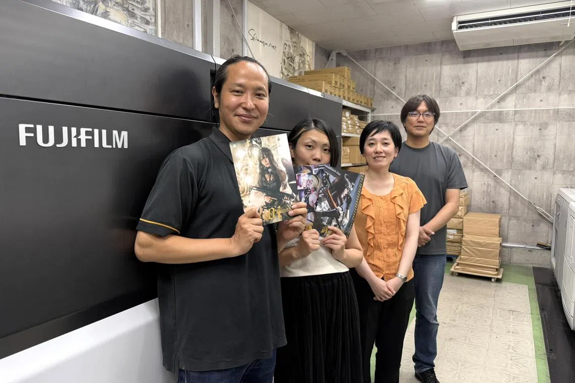 wsletter01 - (L-R) Mr Shinji Kashida and his wife Misato hold up doujinshi photo collections of the latter cosplaying, with Ms Makiko Bujo, 39, of the graphic communication division at Fujifilm Business Innovation Japan, and Mr Masaki Kohayakawa, 53, chief executive officer of Shimaya Printing Corporation, at Shimaya's factory in Tokyo.

ST PHOTO: WALTER SIM