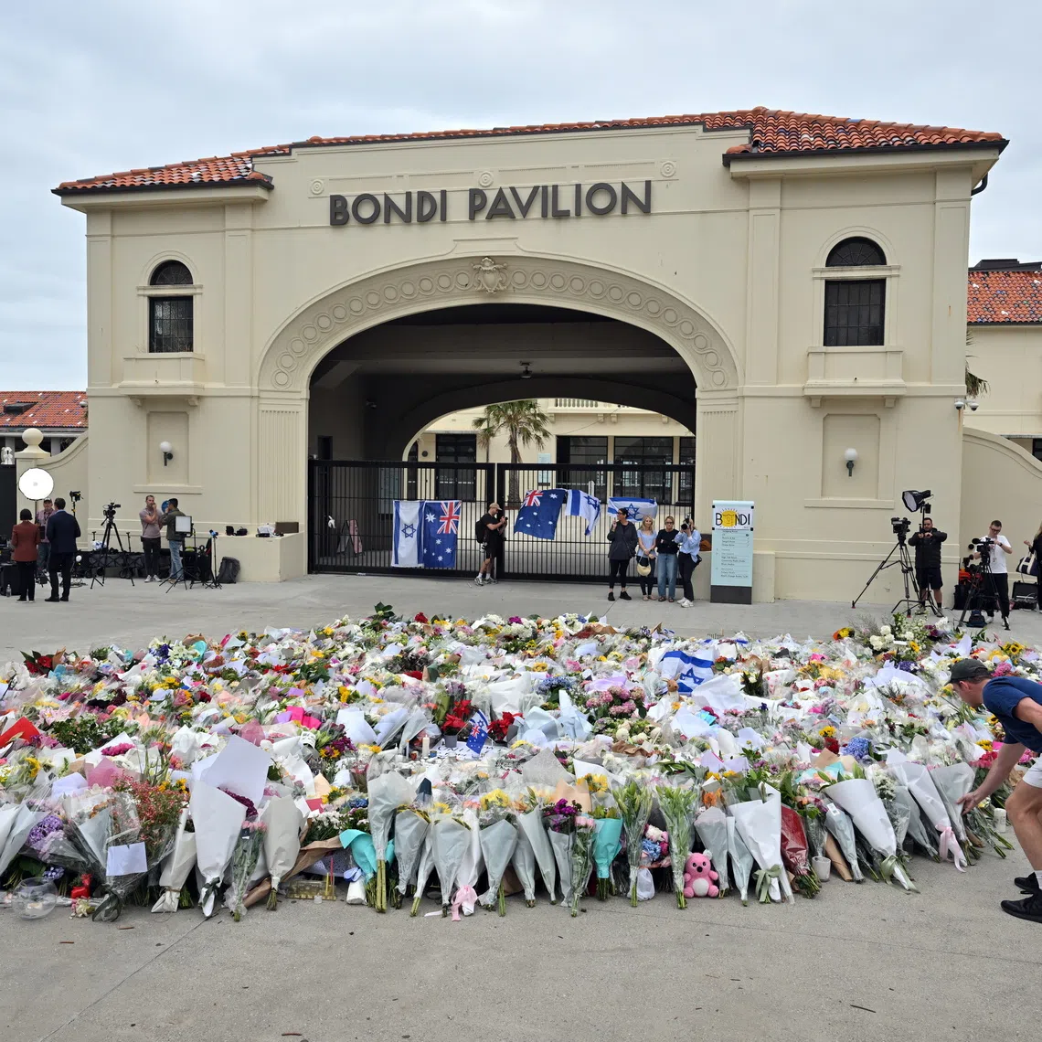 A person lays flowers at a makeshift memorial at Bondi Beach in Sydney, Australia, on Dec 16, 2025.