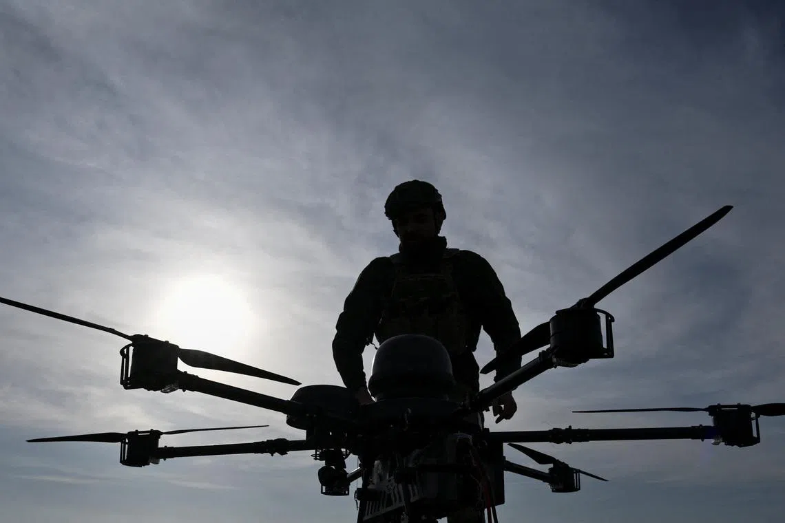 A service member of the 422nd Unmanned Systems Regiment stands next to a heavy strike drone at a training ground, amid Russia's attack on Ukraine, in Zaporizhzhia region, Ukraine March 23, 2026. REUTERS/Stringer
