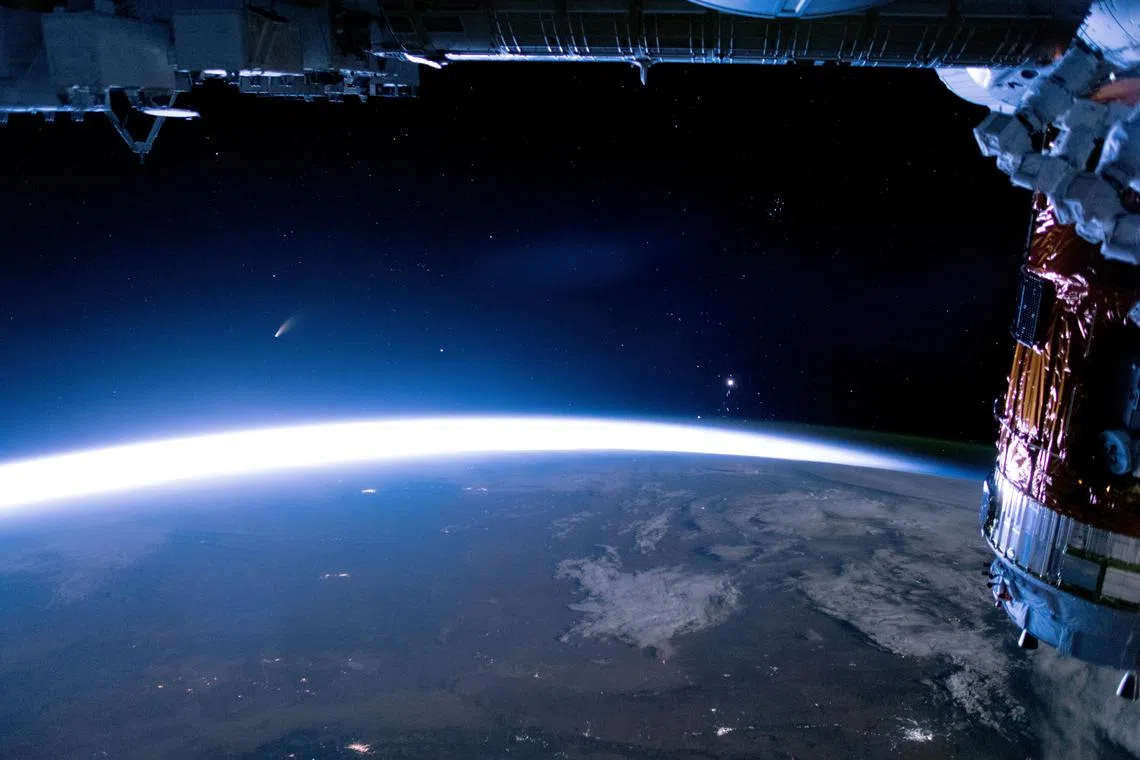 FILE PHOTO: The comet NEOWISE streaks above Earth, in this image taken aboard the International Space Station (ISS),  July 5, 2020. NASA/Handout via REUTERS/FILE PHOTO