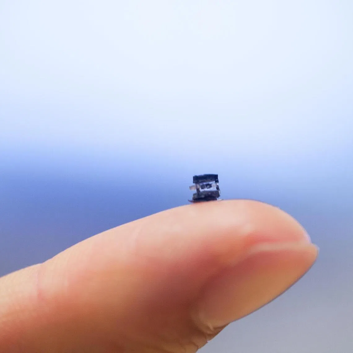 jrntubot30 - Close-up of the 4.4 mm 5-in-1 soft surgical robot on a finger for size comparison.
Credit: NTU Singapore