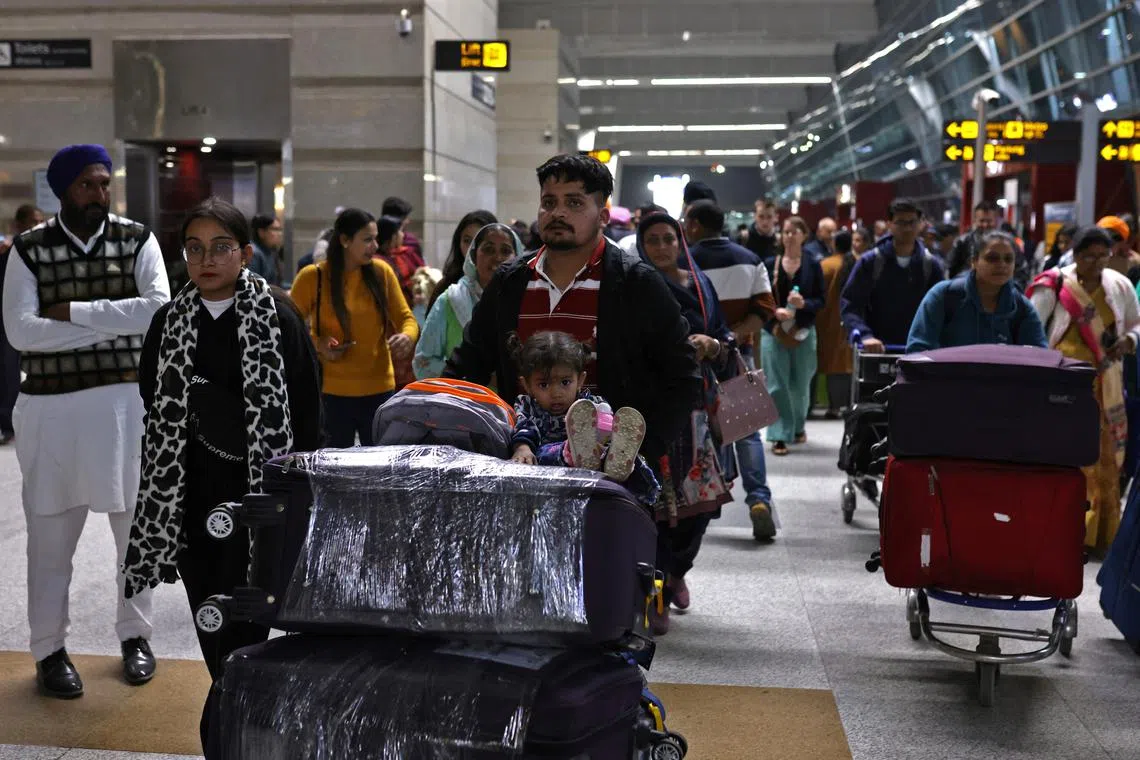 FILE PHOTO: Travellers push trolleys with their luggage at the departure area of Indira Gandhi International Airport in New Delhi, India, December 14, 2022. REUTERS/Anushree Fadnavis/File Photo