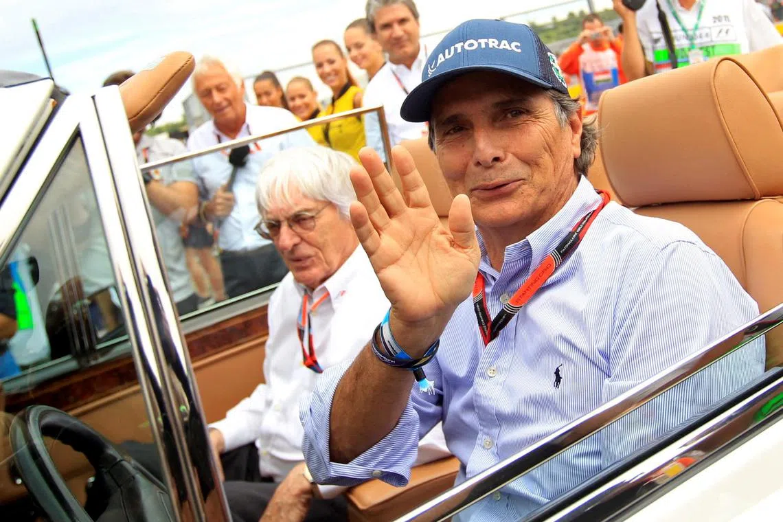 Former Formula One driver Nelson Piquet of Brazil (right) and Formula One supremo Bernie Ecclestone arrive at the drivers' parade before the Hungarian Grand Prix in July 2015.