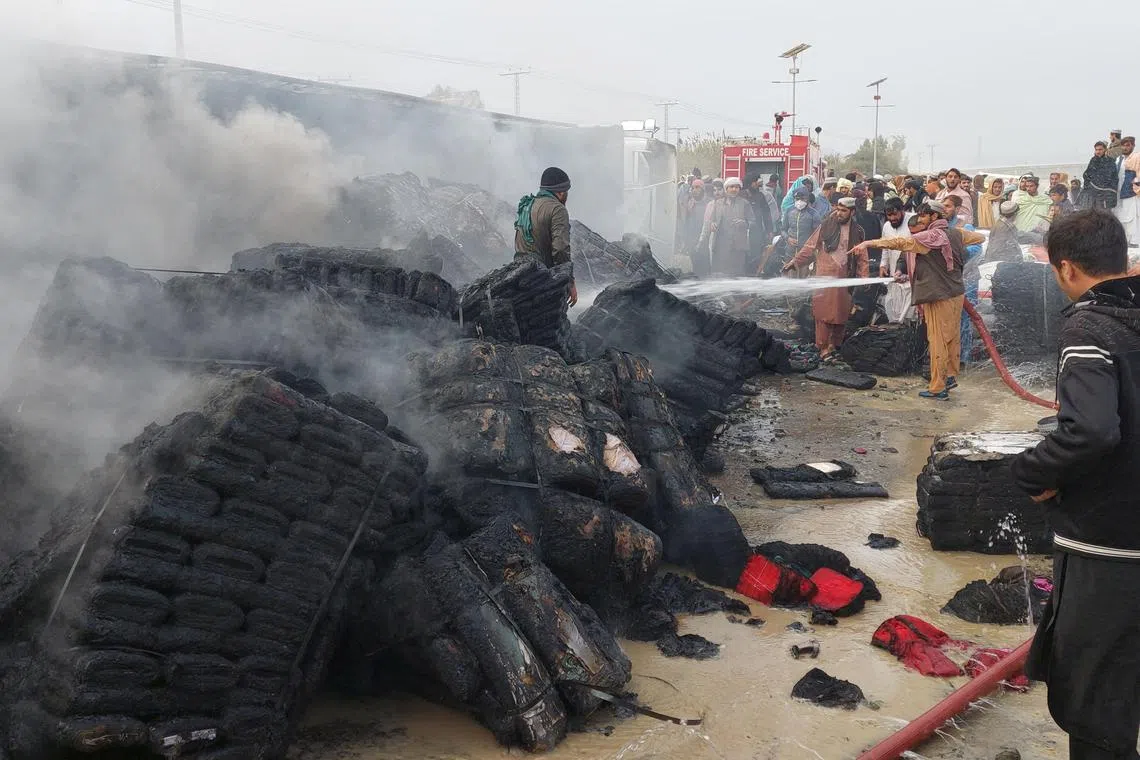 People douse a cargo supply truck after it was hit during the artillery shelling.