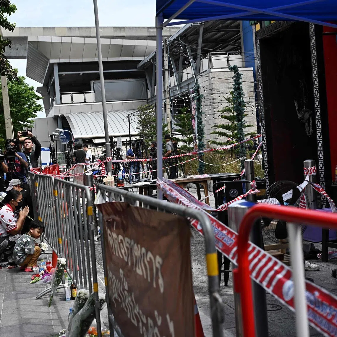 People pay their respects to victims of a fire in front of the Rong Beer Na Lat Phrao bar in Bangkok on July 14.