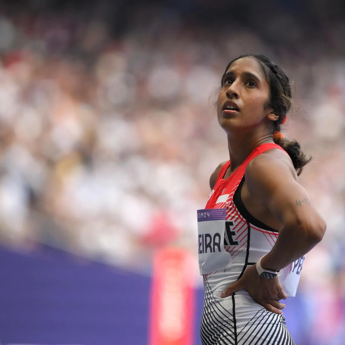 Singapore sprinter Shanti Pereira (left) checks the scoreboard after the Paris 2024 Olympics Women's Athletics 100m round 1 at the Stade de France on August 2, 2024.