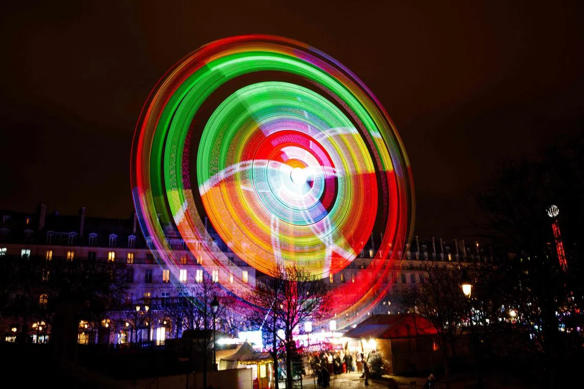 Visitors riding on a carousel at the seasonal fairground in the Tuileries Gardens in central Paris on Nov 23, 2023. 