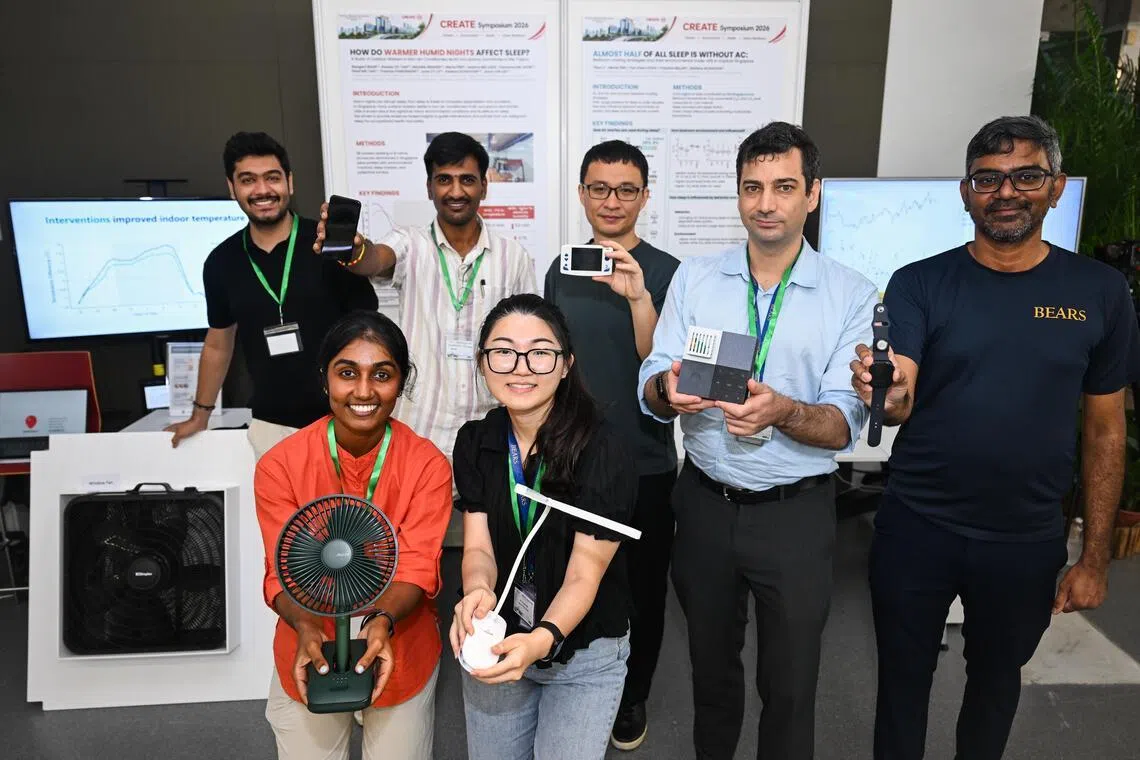 Raagavi Mani (in orange) and her colleagues showcasing the devices and tools they used for HEATS at the CREATE Symposium.