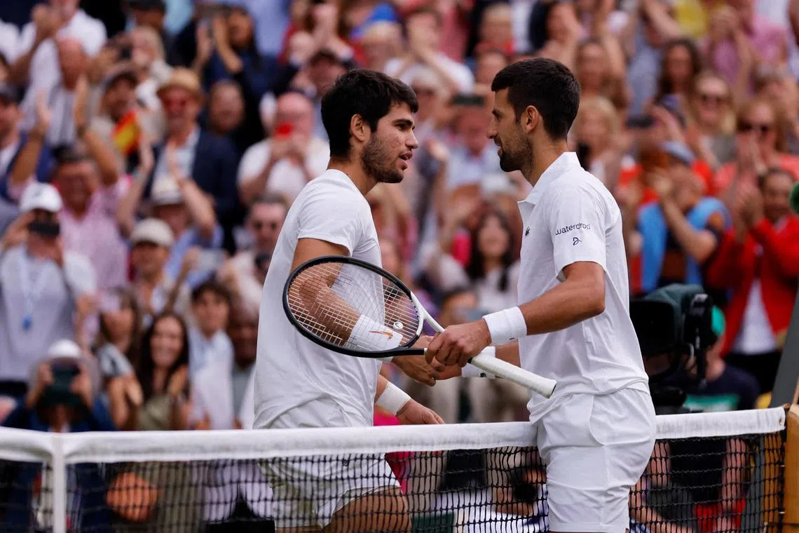 Spain's Carlos Alcaraz with Serbia's Novak Djokovic after winning the 2023 Wimbledon final.