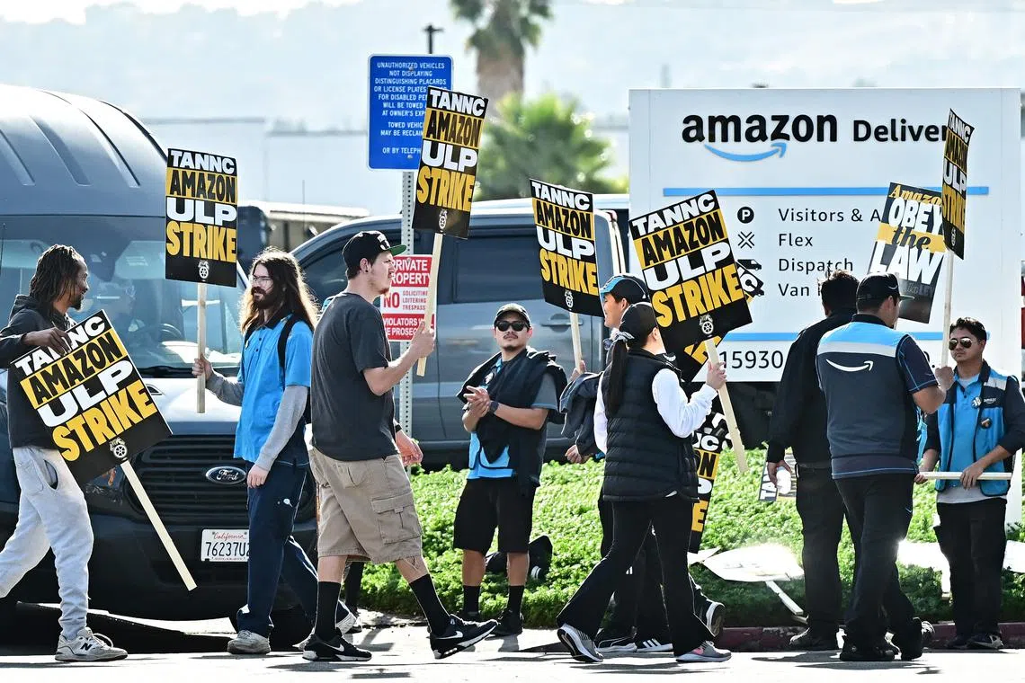 Amazon workers walk the picket line outside an Amazon facility in the City of Industry, California on December 19, 2024. Thousands of workers at Amazon facilities across the United States went on strike December 19, 2024, the Teamsters Union said, halting work at the height of the busy holiday gift-giving season. (Photo by Frederic J. BROWN / AFP)